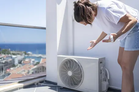 a woman checking the AC unit