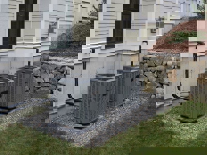 two modern condensers outside a home