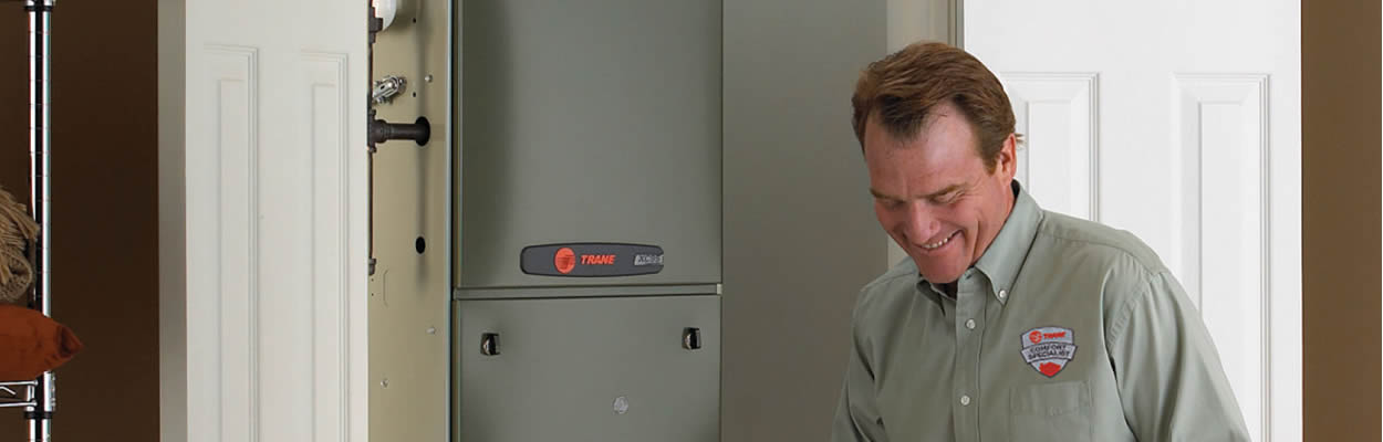 Trane Tech Next To Furnace Writing On Clipboard Trane Tech Next To Furnace Writing On Clipboard