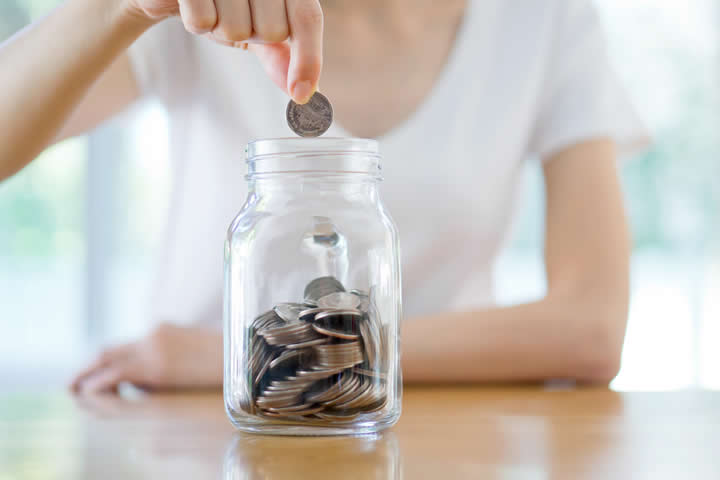 Woman Dropping Coins In Jar Woman Dropping Coins In Jar